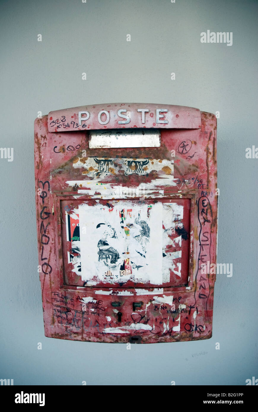 a dirty red italian post box on a grey wall Stock Photo - Alamy