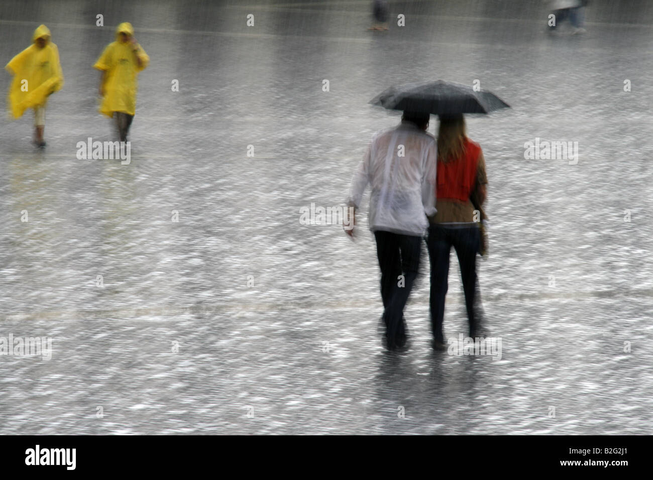 young couple sharing an umbrella in heavy rain Stock Photo - Alamy