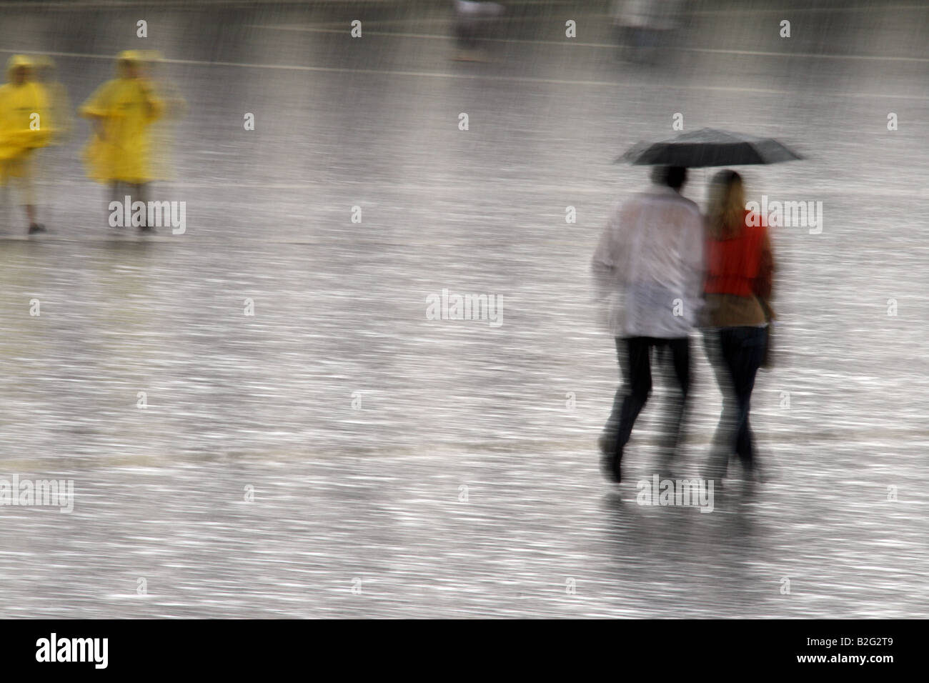 young couple sharing an umbrella in heavy rain Stock Photo - Alamy