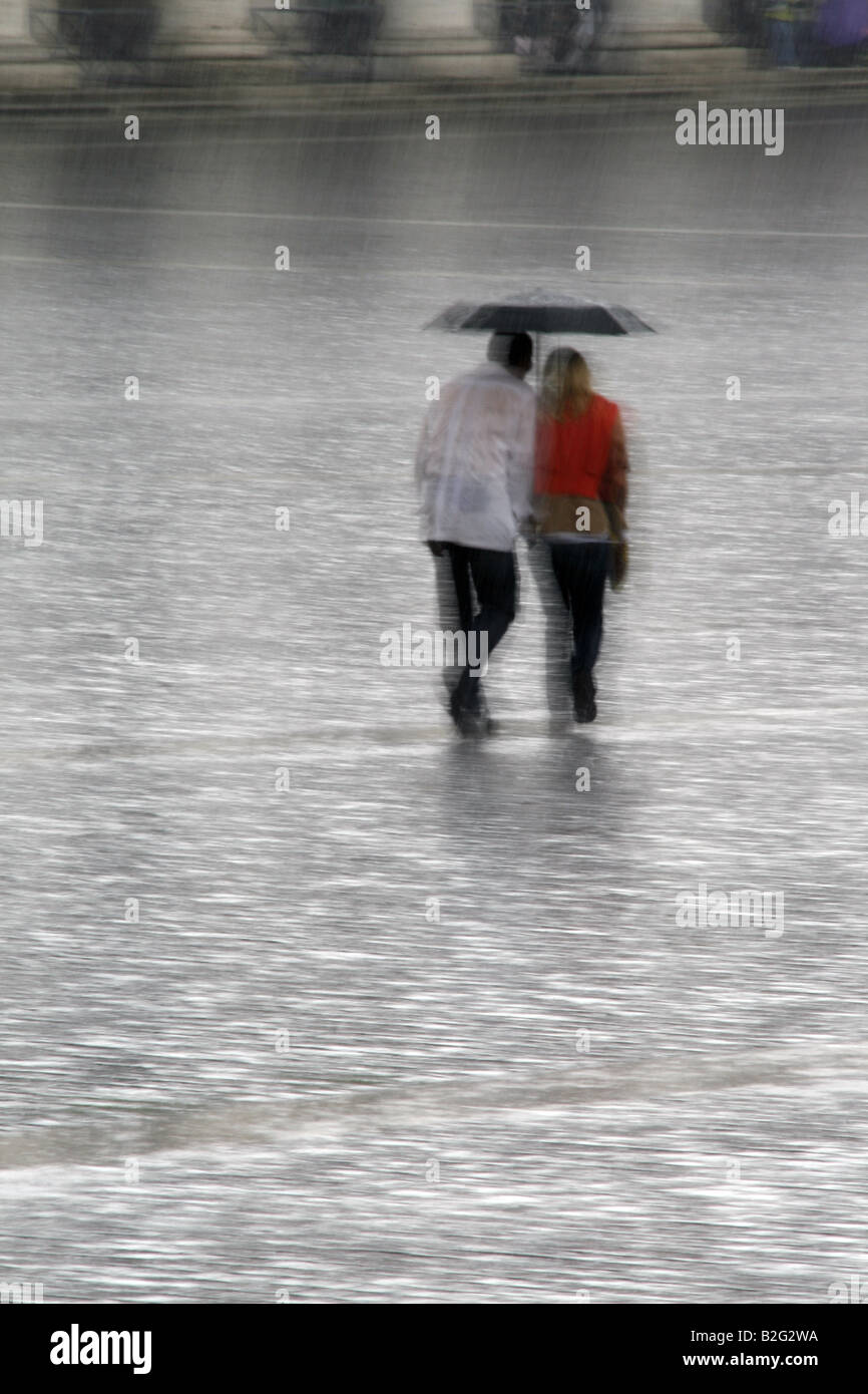 young couple sharing an umbrella in heavy rain Stock Photo - Alamy