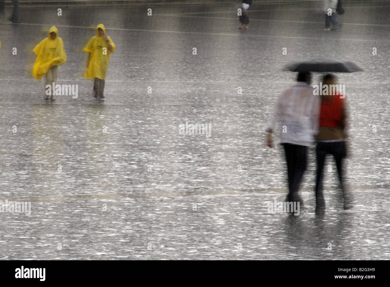 young couple sharing an umbrella in heavy rain Stock Photo - Alamy