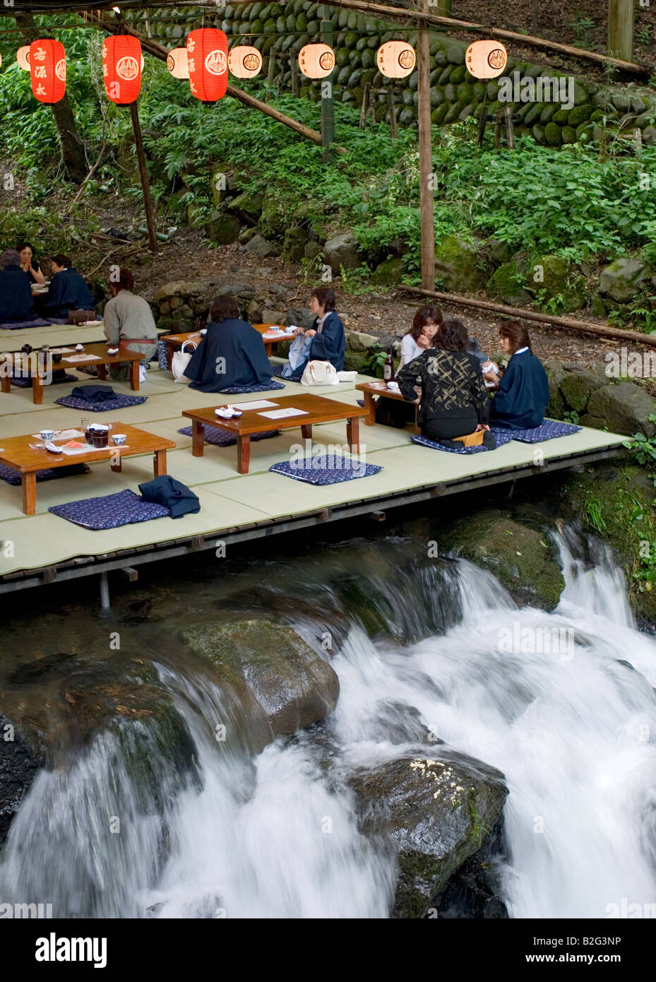 Restaurant patrons have lunch above the rushing water of the Kibune River while enjoying cool breezes during hot summer months Stock Photo