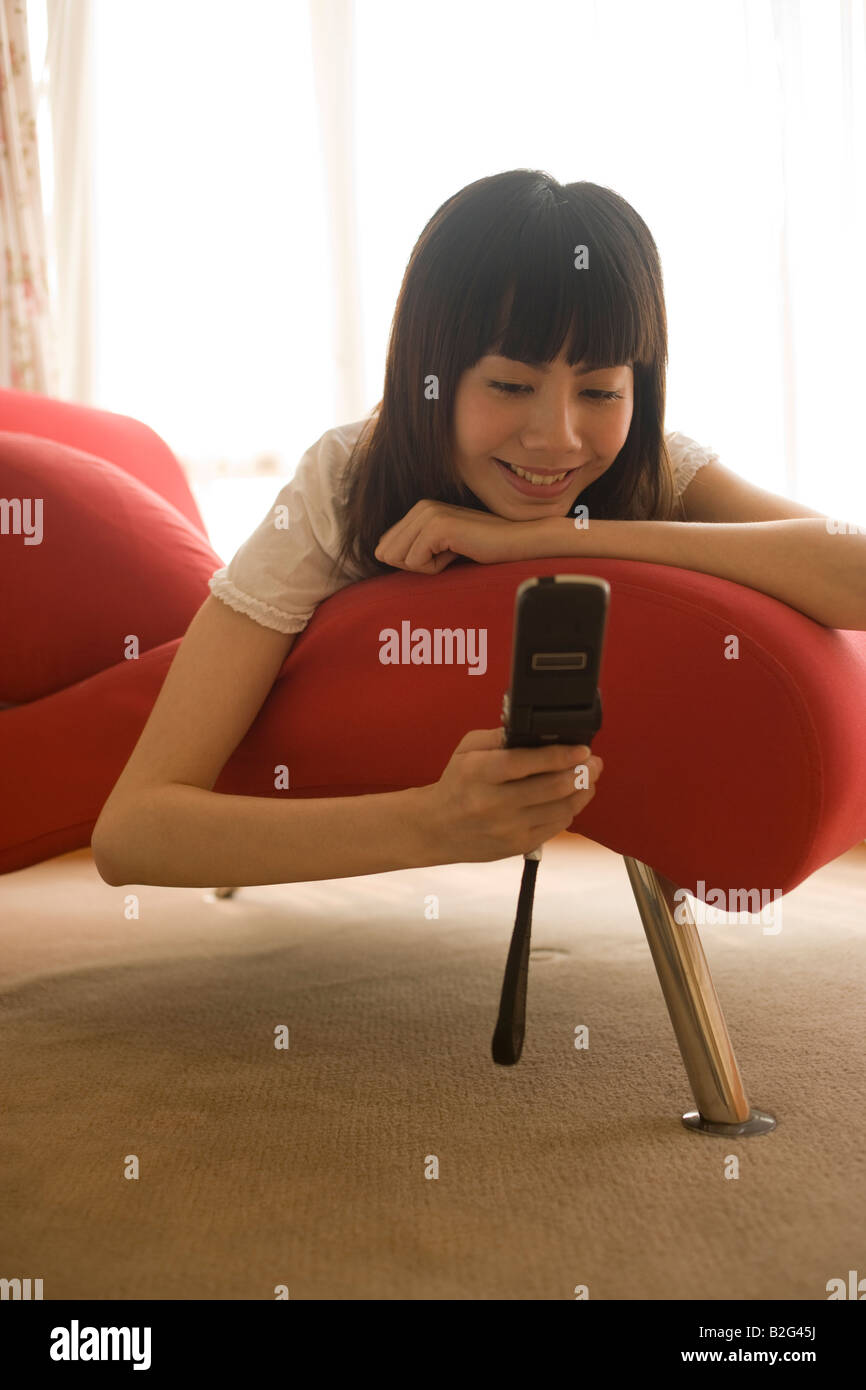 Young woman text messaging and smiling Stock Photo - Alamy