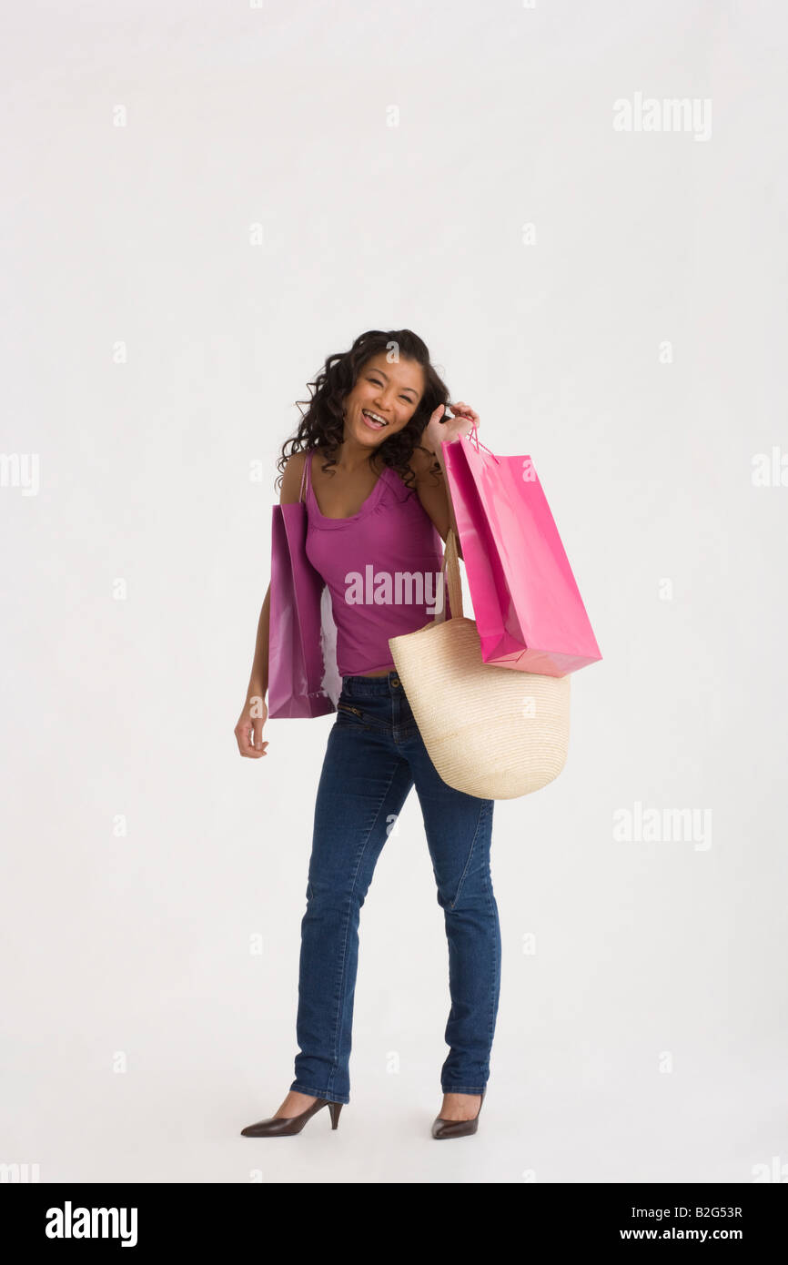 Young woman carrying shopping bags and smiling Stock Photo - Alamy