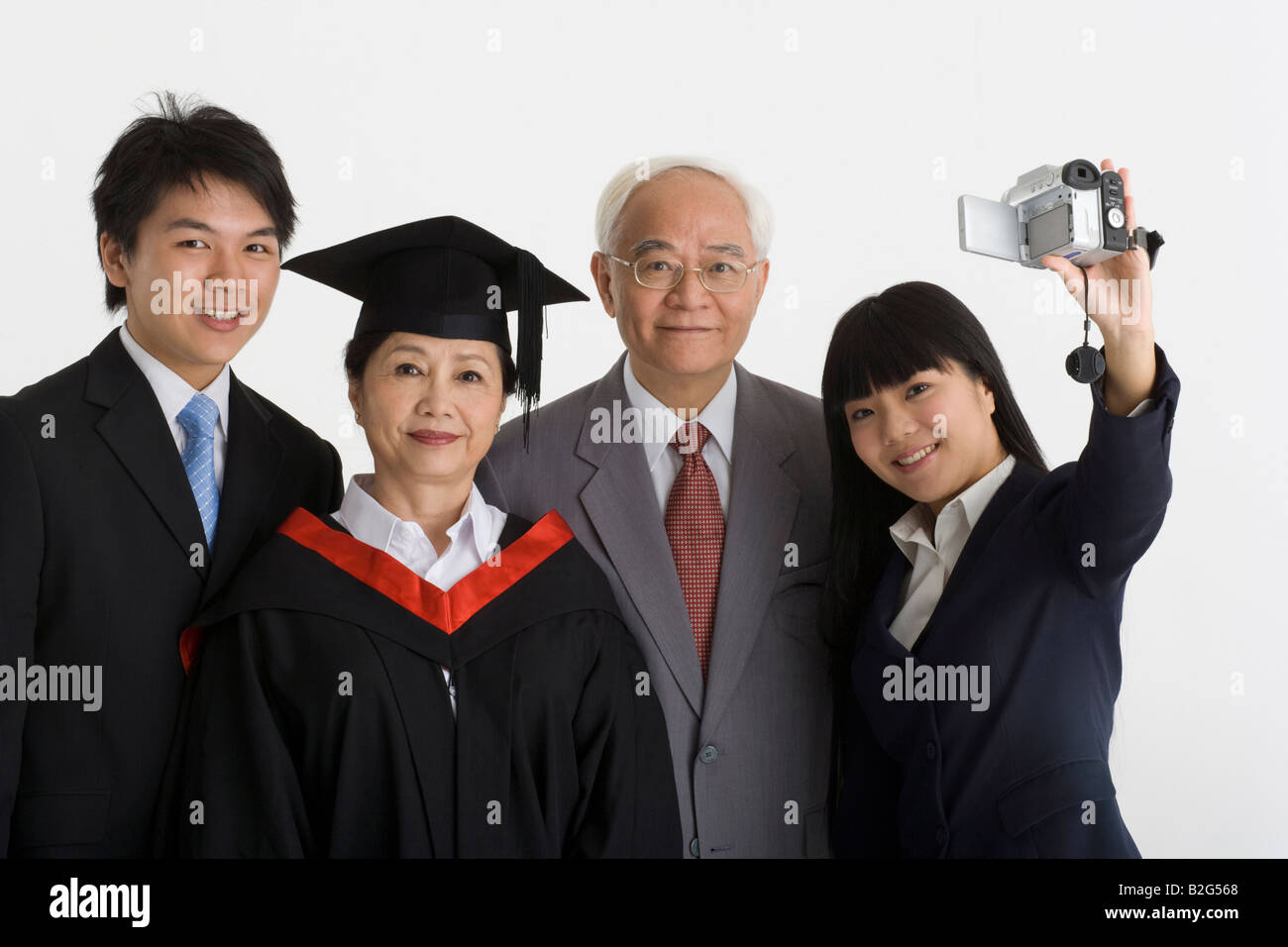 Family Using Filming Camera Portrait of a young woman with her family filming themselves with a ...
