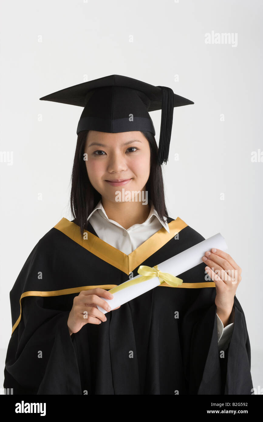 Portrait of a young female graduate holding a diploma and smiling Stock ...
