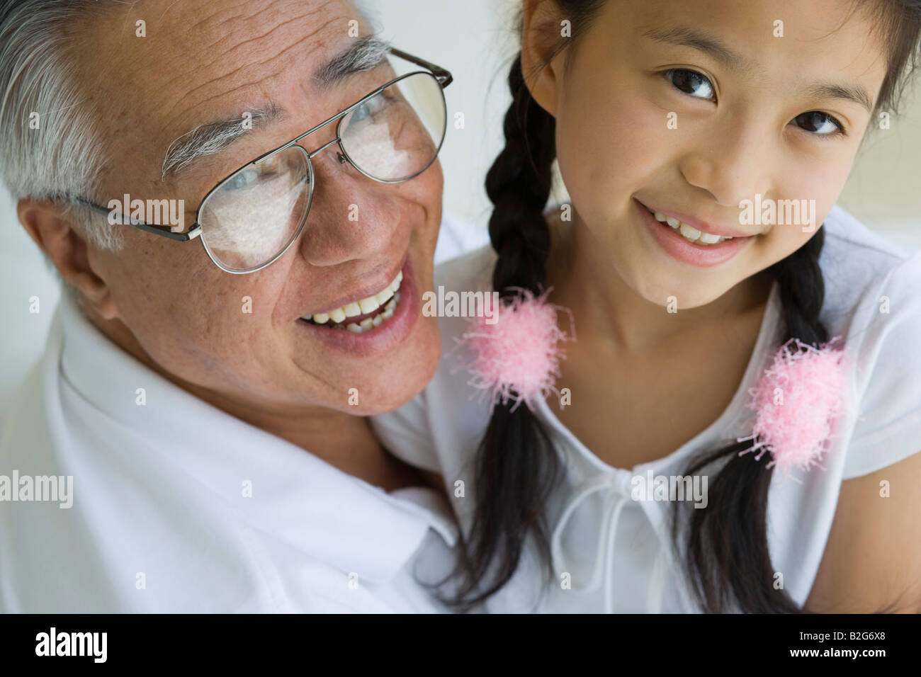 Portrait of a senior man smiling with his granddaughter Stock Photo