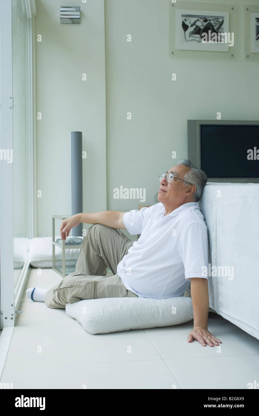 Senior man sitting on the floor and thinking Stock Photo - Alamy