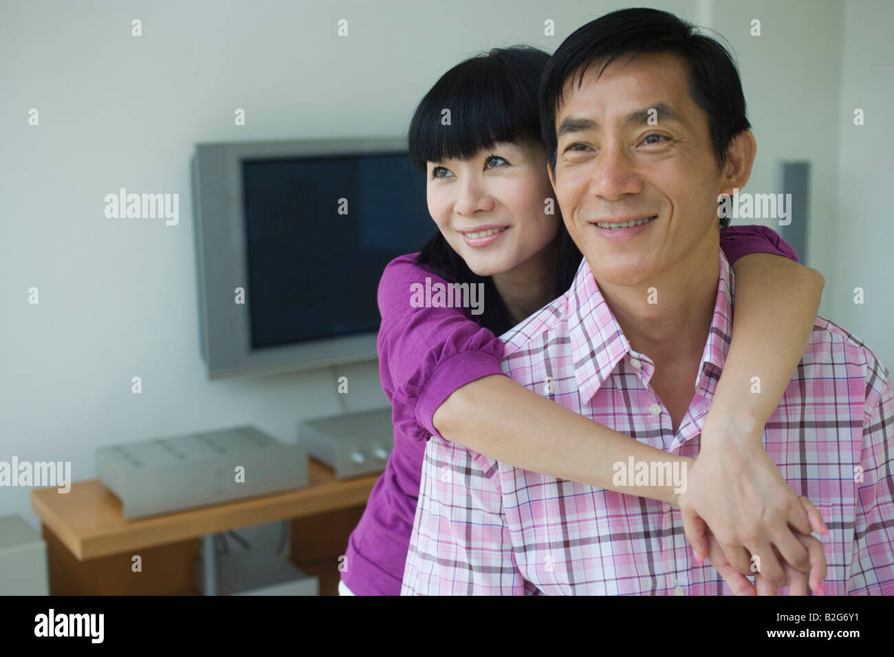 Mid adult woman embracing a mid adult man from behind Stock Photo - Alamy