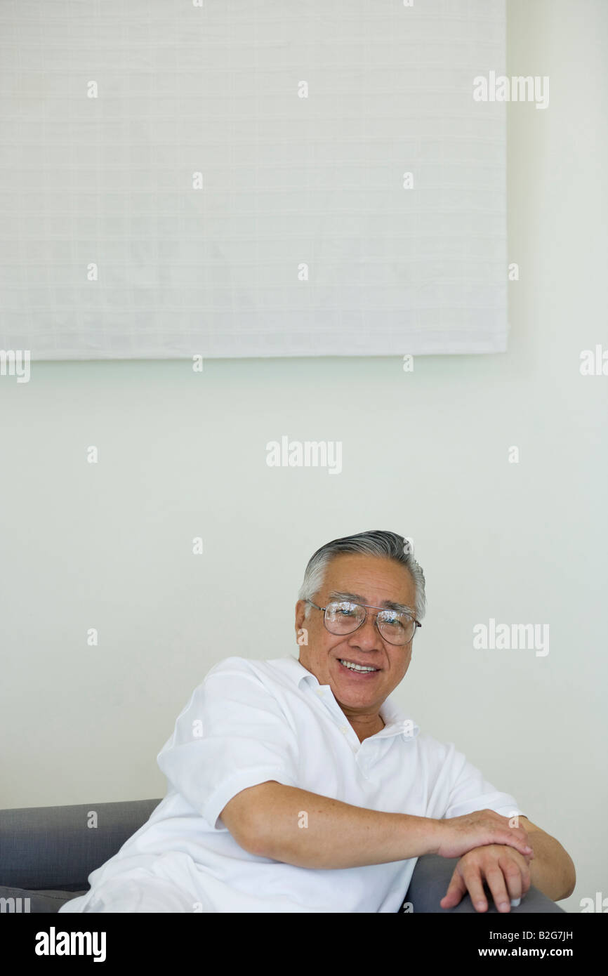 Portrait of a senior man sitting on a couch and smiling Stock Photo - Alamy