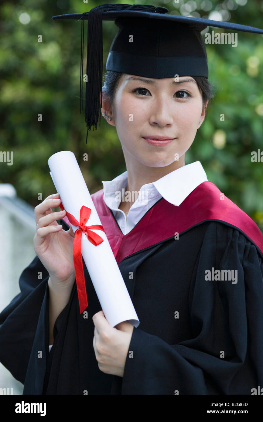 Portrait of a young female graduate holding a diploma Stock Photo - Alamy
