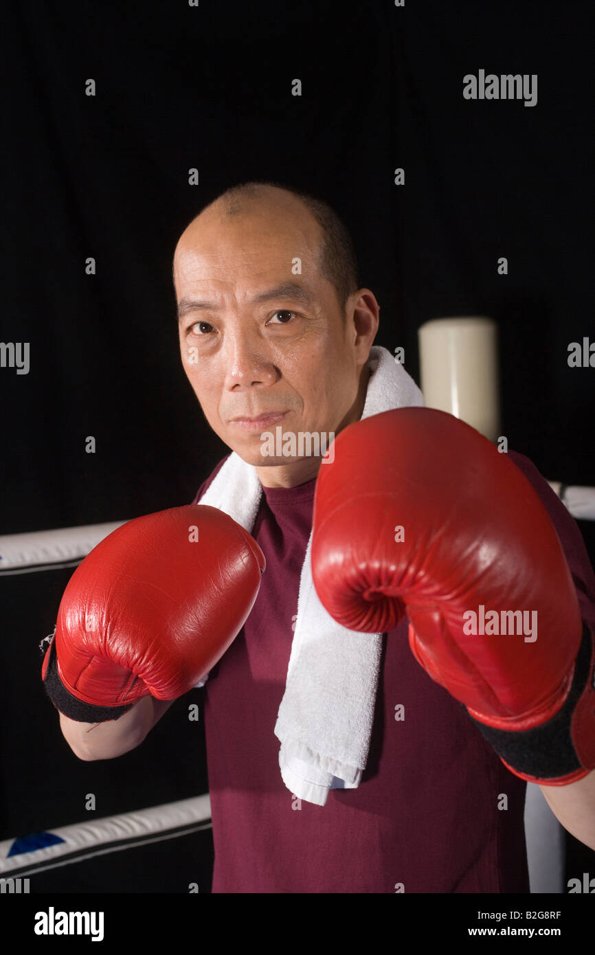 Mature man wearing boxing gloves in a boxing ring Stock Photo