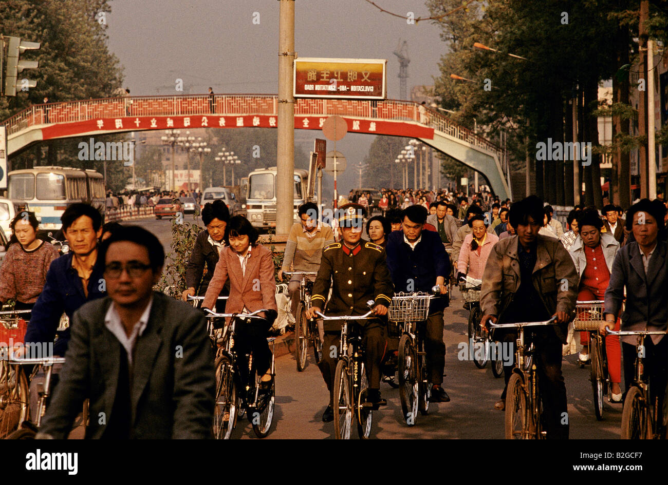 one soldier rides bicycle amongst hundreds of cyclists shanghai, china Stock Photo