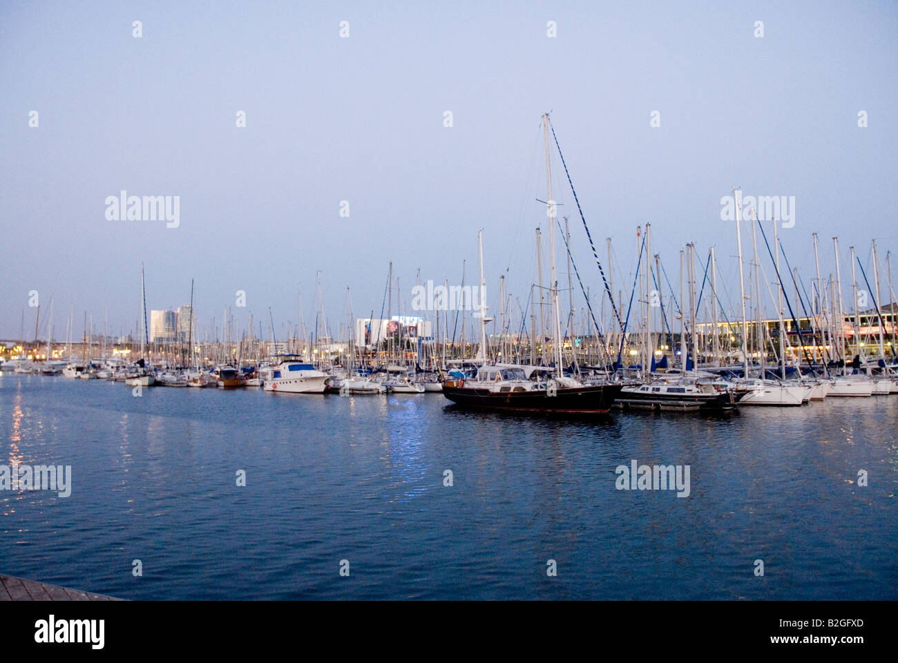 Rambla de Mar Port Vell bridge in the evening or night with ships Barcelona Stock Photo