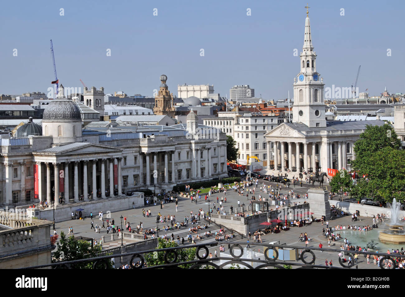 Aerial view looking down on sightseeing tourists in historical Trafalgar Square spire of St Martin in the Fields church & National Gallery London UK Stock Photo