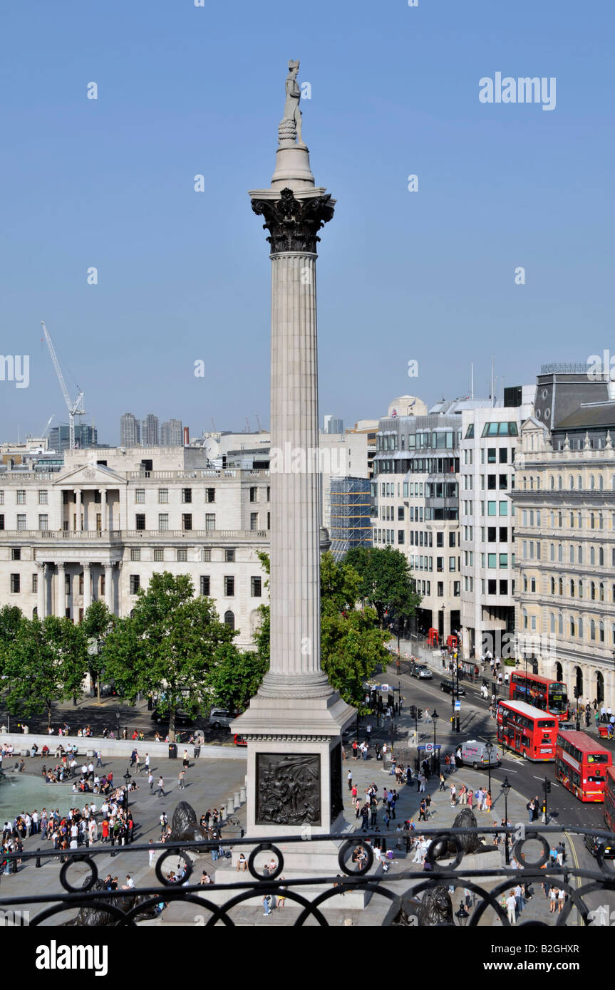 Aerial view from above looking down on tourists and visitors around Nelsons Column in Trafalgar Square with red London buses in the Strand England UK Stock Photo