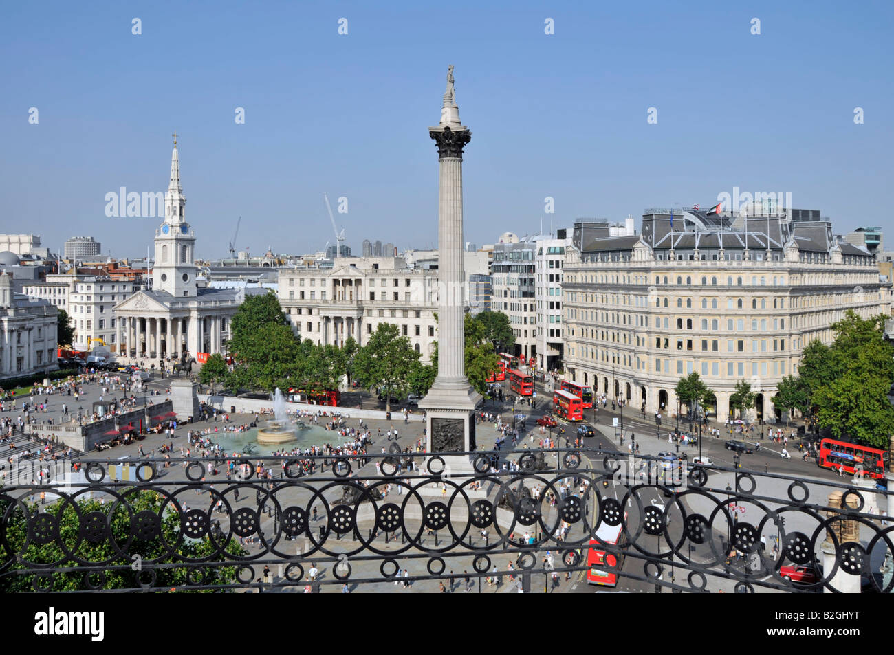 Aerial view of tourists & visitors in and around Trafalgar Square, includes St Martin in the Fields church fountain & Nelson column London England UK Stock Photo