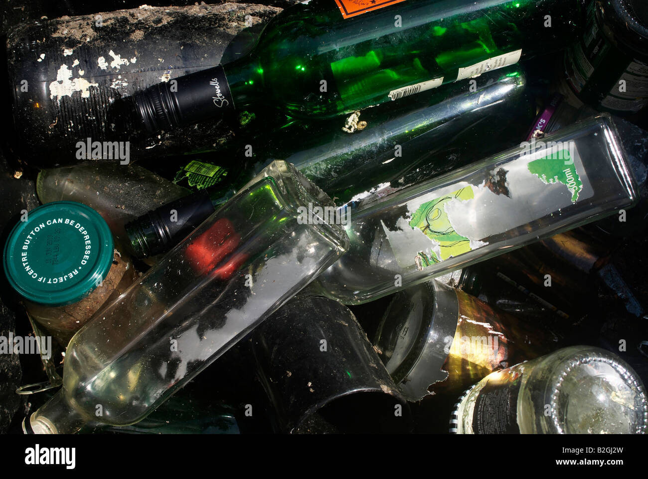 Glass bottles laying in a bin discarded and ready for recycling. Stock Photo