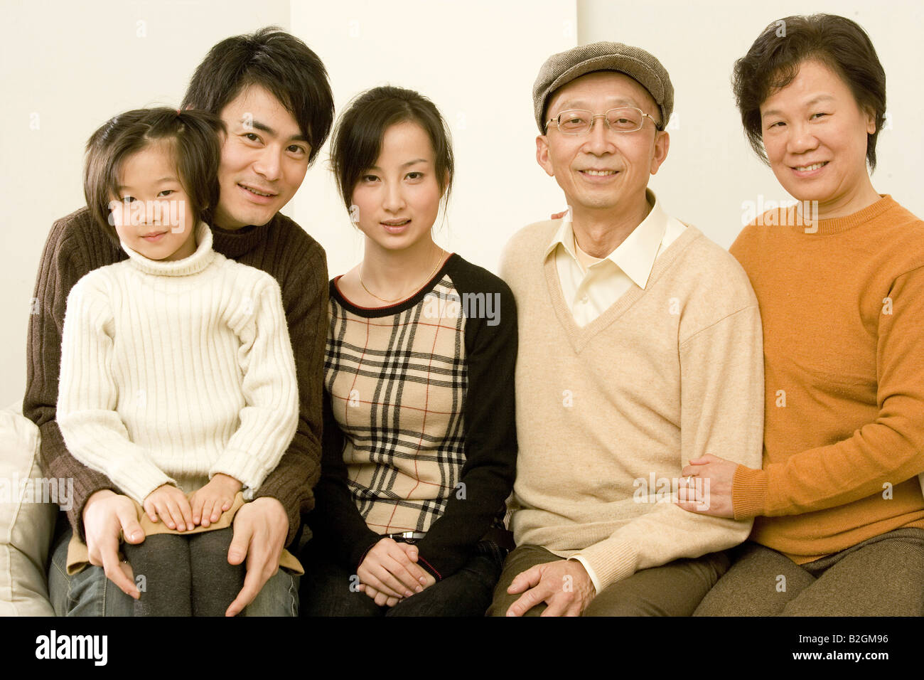 Portrait of a family sitting side by side Stock Photo - Alamy