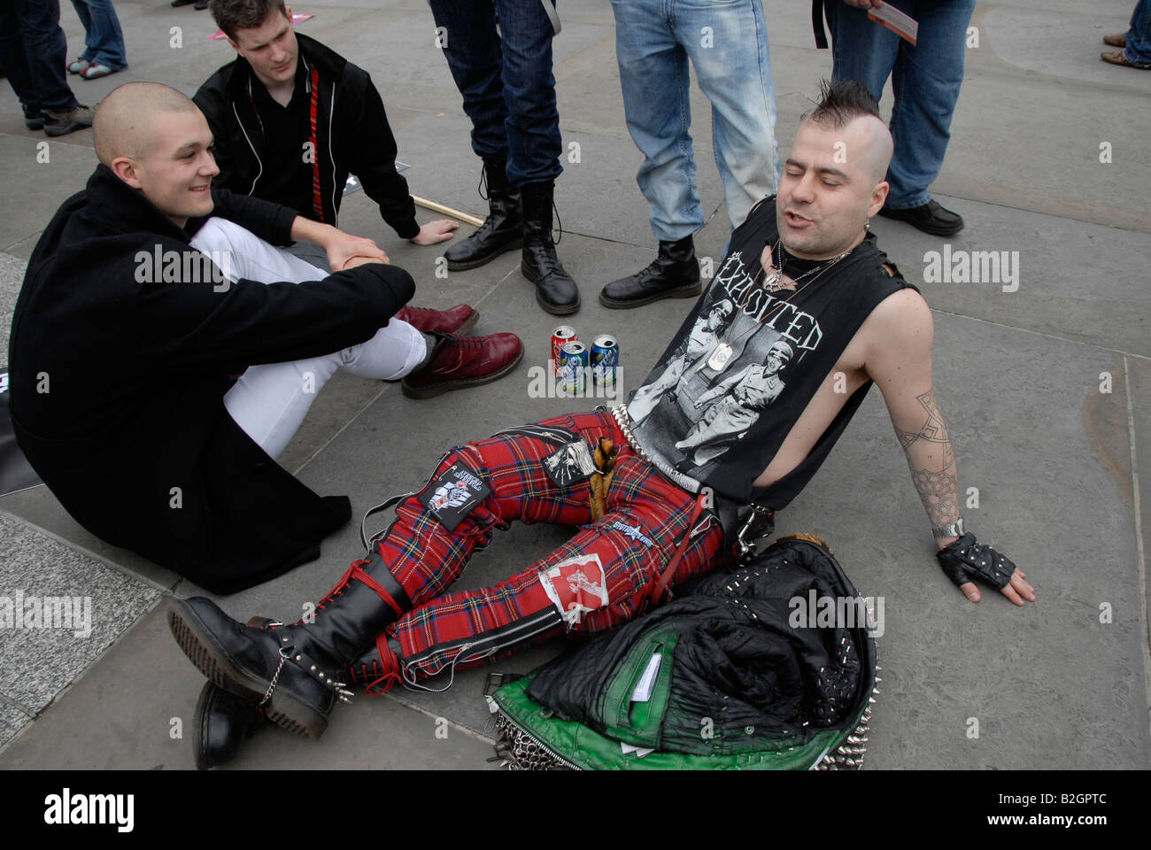 Punk youth sitting on pavement Stock Photo