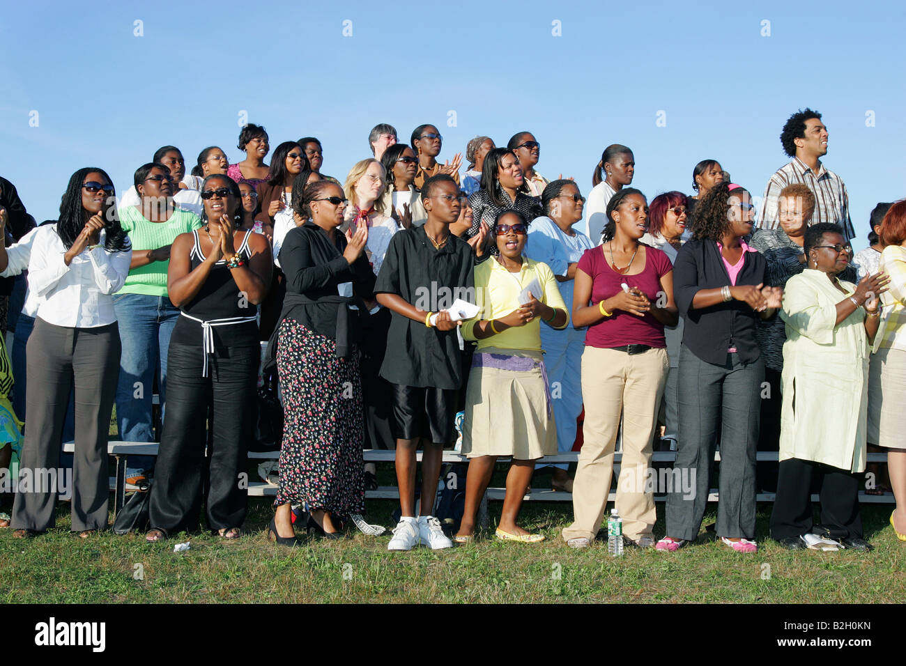 A multiracial group sings during an outdoor prayer service Stock Photo