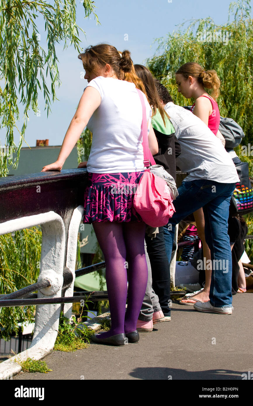 London , Stylish pretty female young girl in purple mini skirt and tights  watch passing traffic from bridge over canal Stock Photo - Alamy