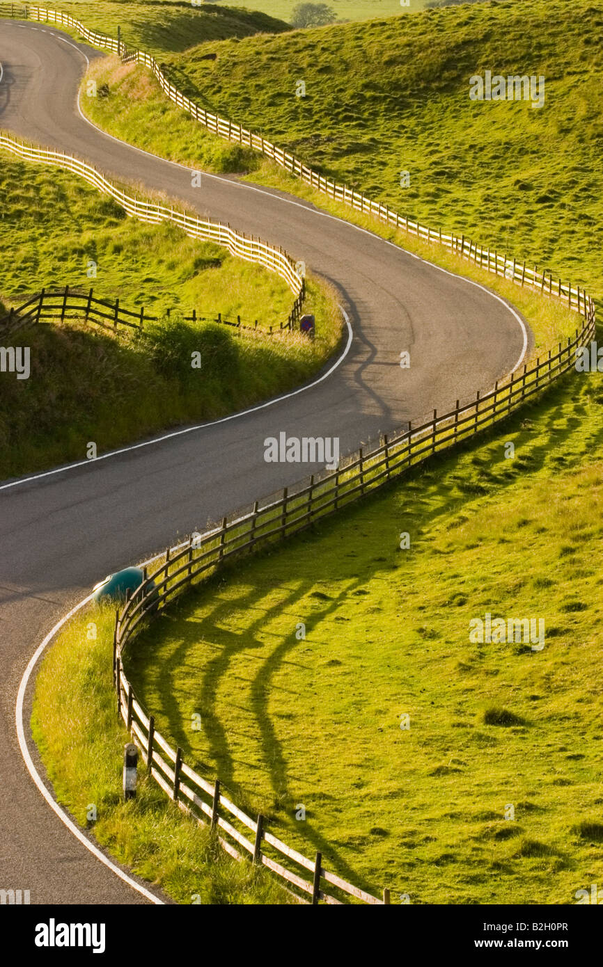A winding road in evening light and shadows Stock Photo
