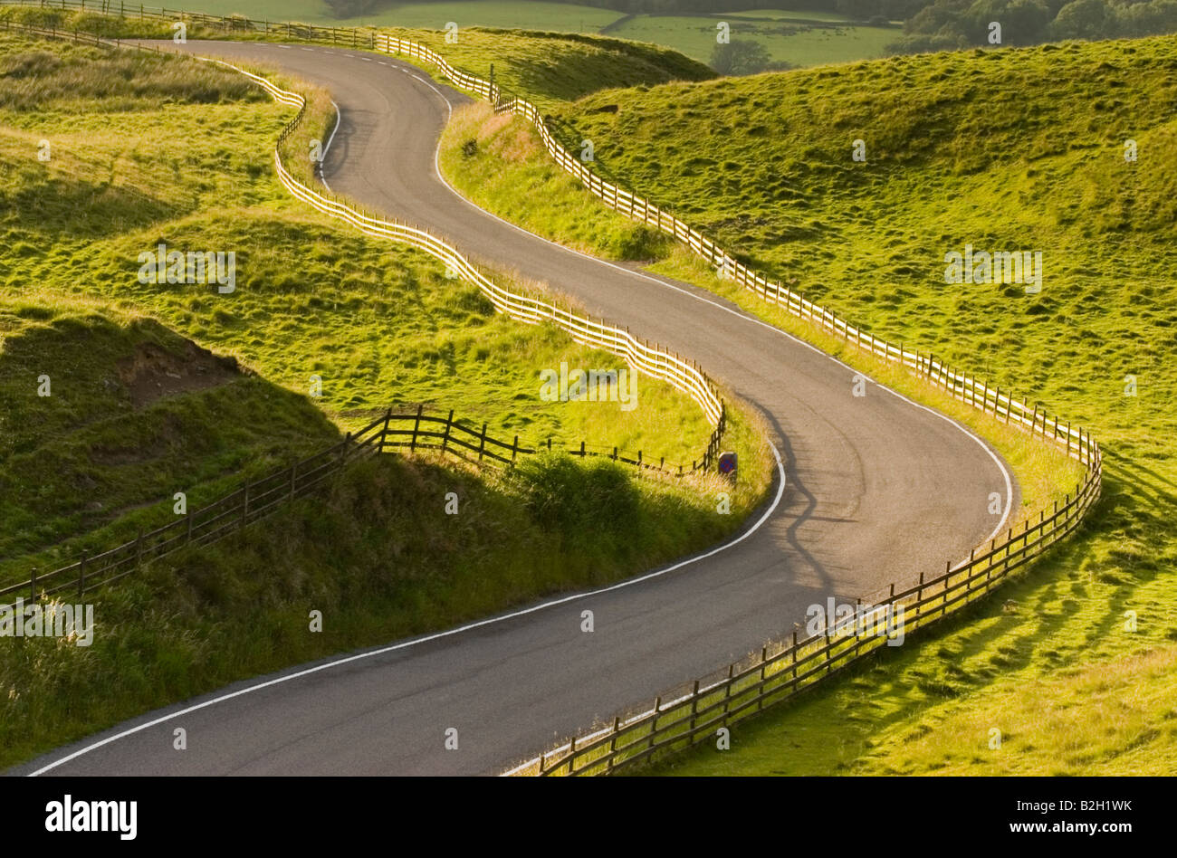 A road winding its way through green hilly landscape Stock Photo