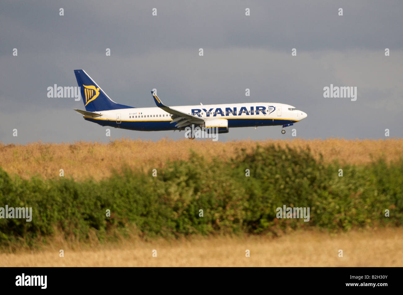 Ryanair Boeing 737 Stansted heat haze effect appearing to land on a hilly wheat field Stock Photo