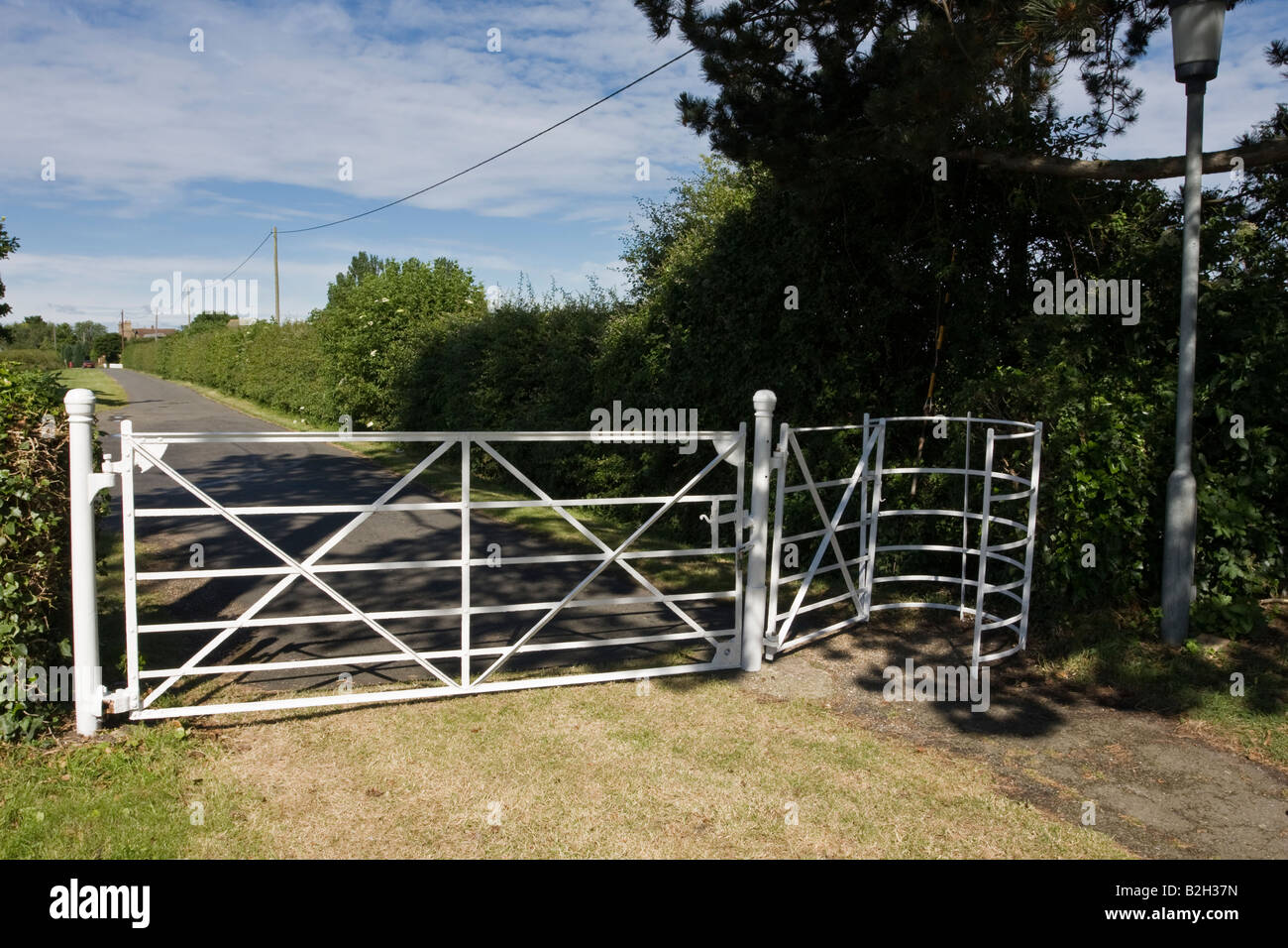 White Iron Gate and Kissing gate All Saints Church Little Staughton Bedfordshire Stock Photo