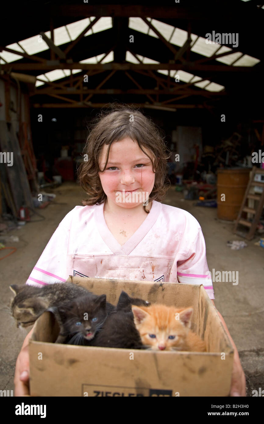 Young girl in rural Iowa, holding box of new kittens, Iowa, USA Stock Photo