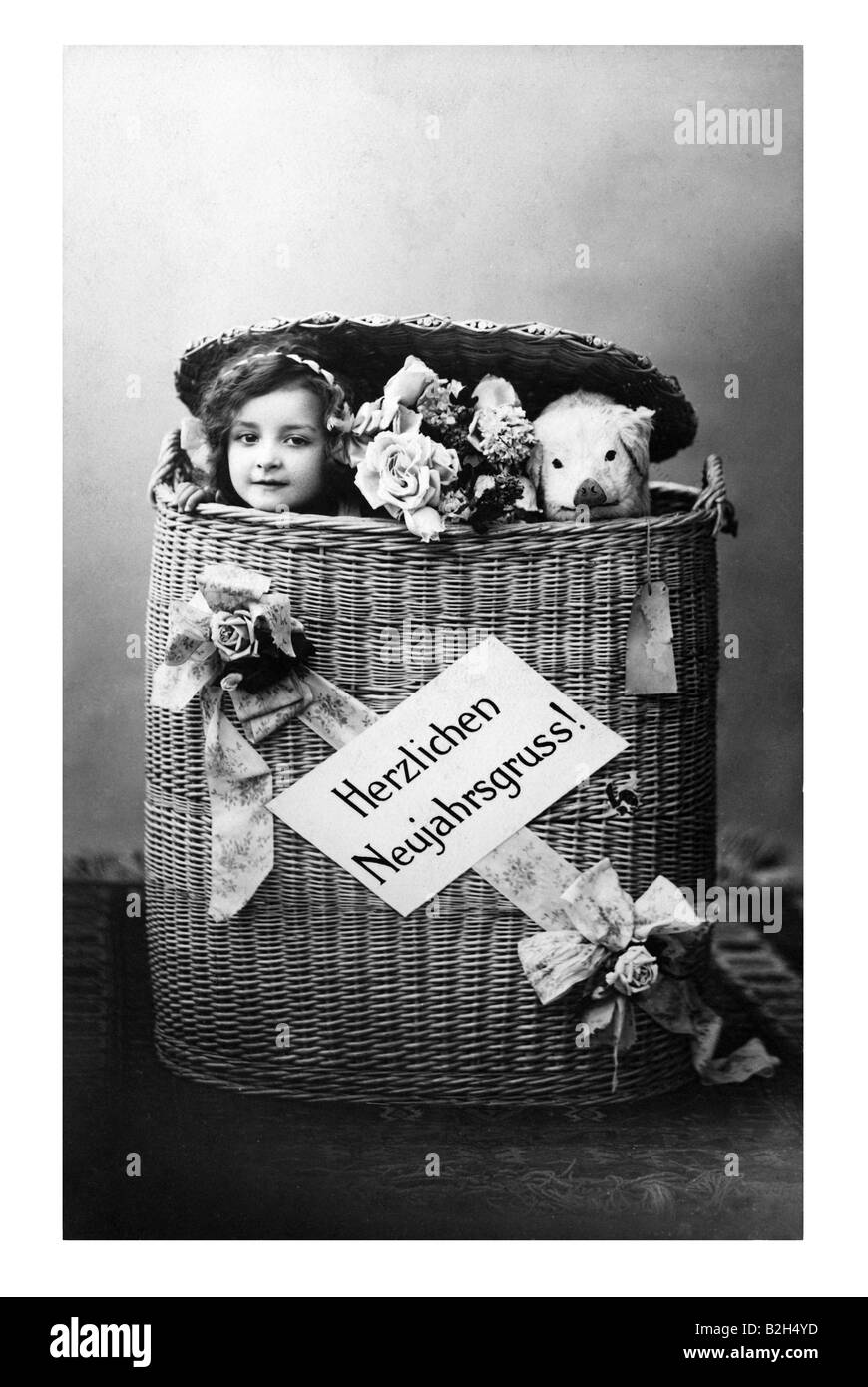 Germany Postcard motive cute girl and piggy in basket greetings 19th century Stock Photo
