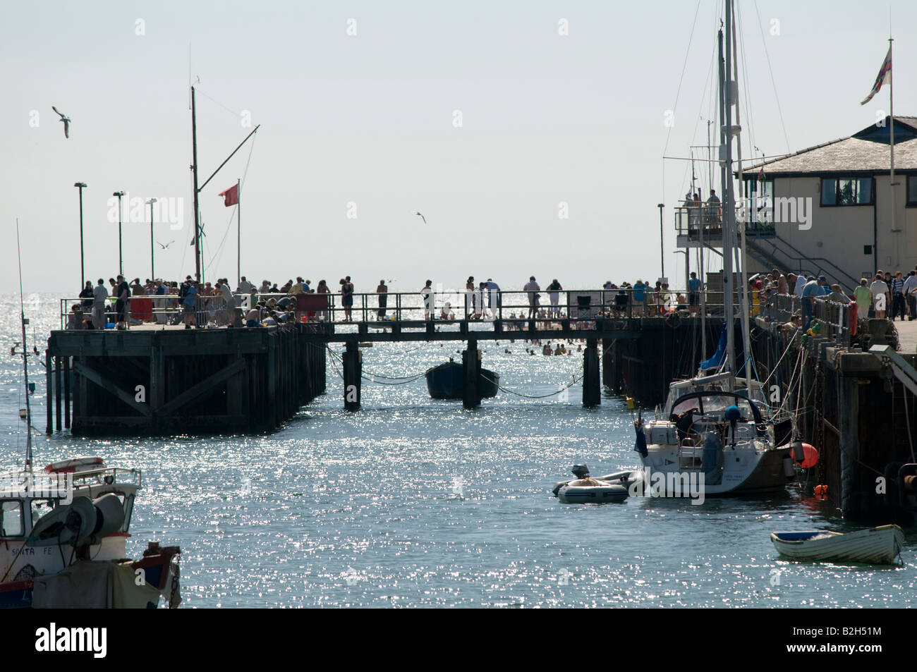 people on the wooden jetty or pier at Aberdyfi Gwynedd north wales on a summer afternoon Stock Photo