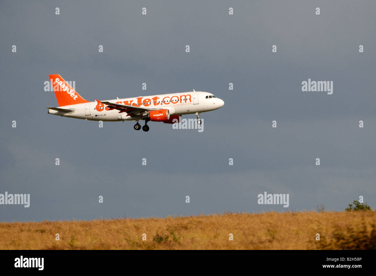 easyJet Airbus A319 Stansted heat haze effect appearing to land on a hilly wheat field Stock Photo