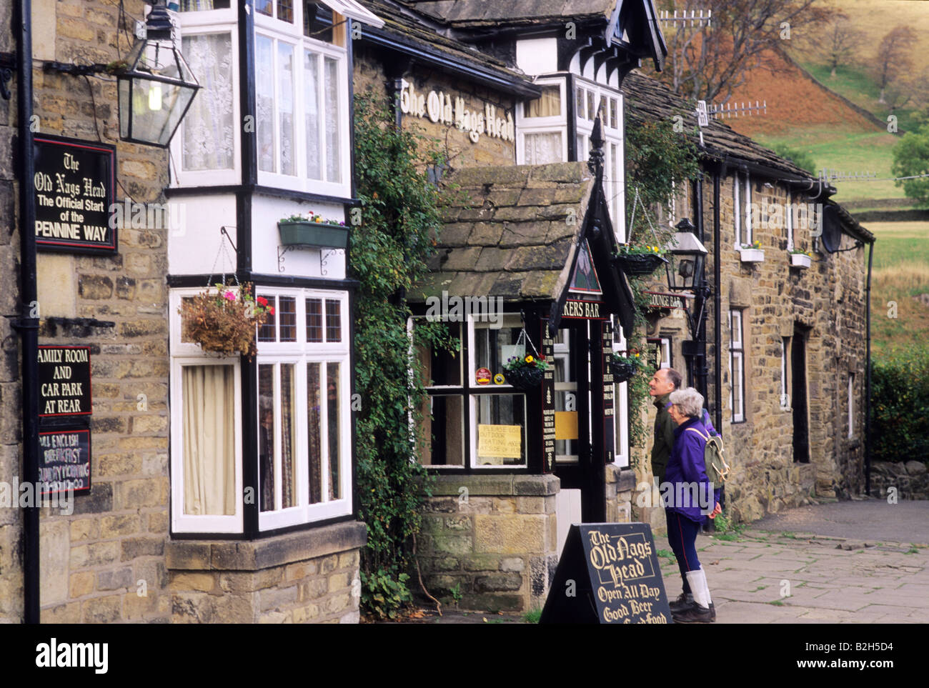 Old Nags Head Pub walkers hikers couple reading bar menu Pennine Way Derbyshire England UK Peak District backpack walking boots Stock Photo