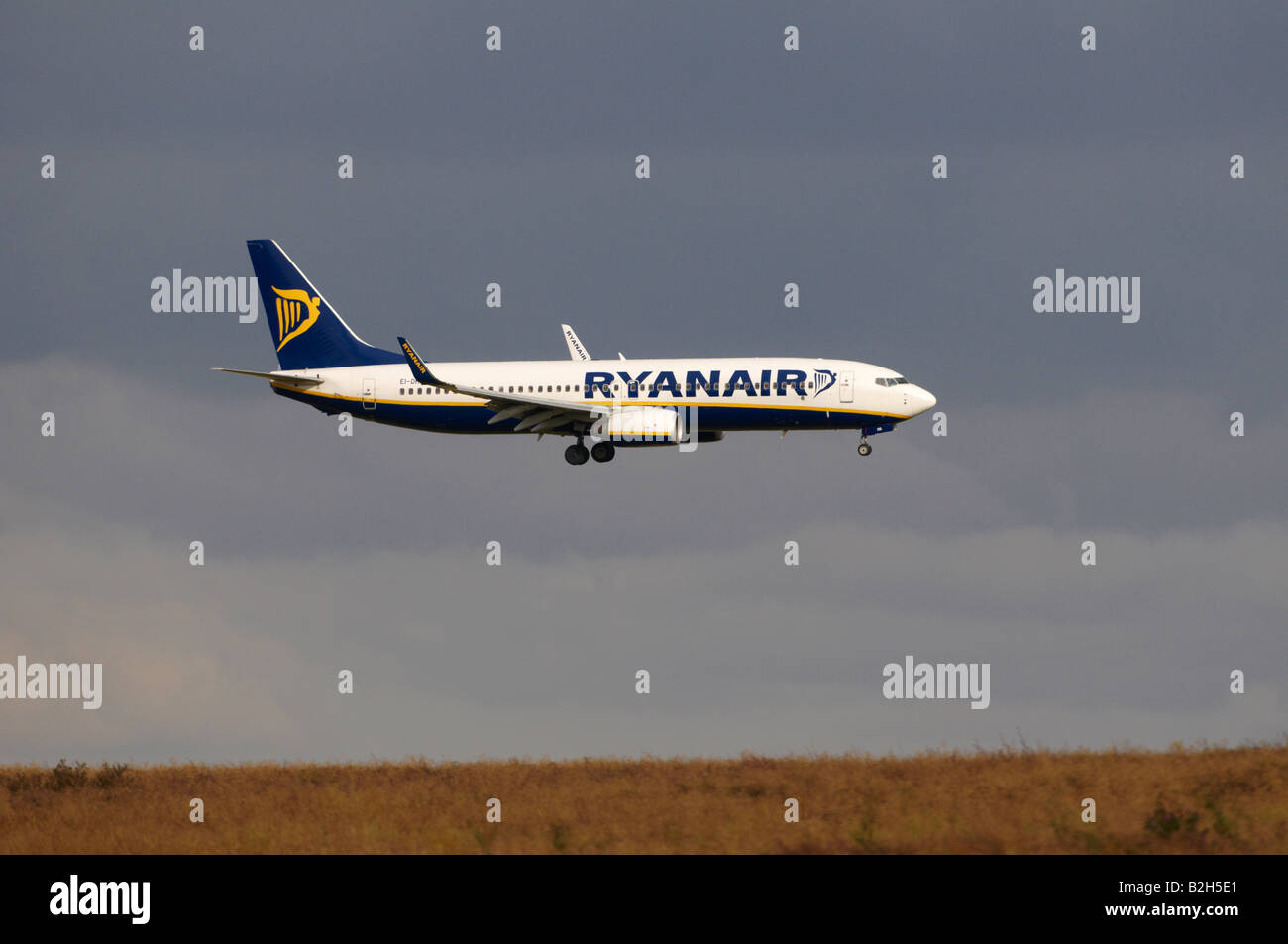 Ryanair Boeing 737 Stansted heat haze effect appearing to land on a hilly wheat field Stock Photo