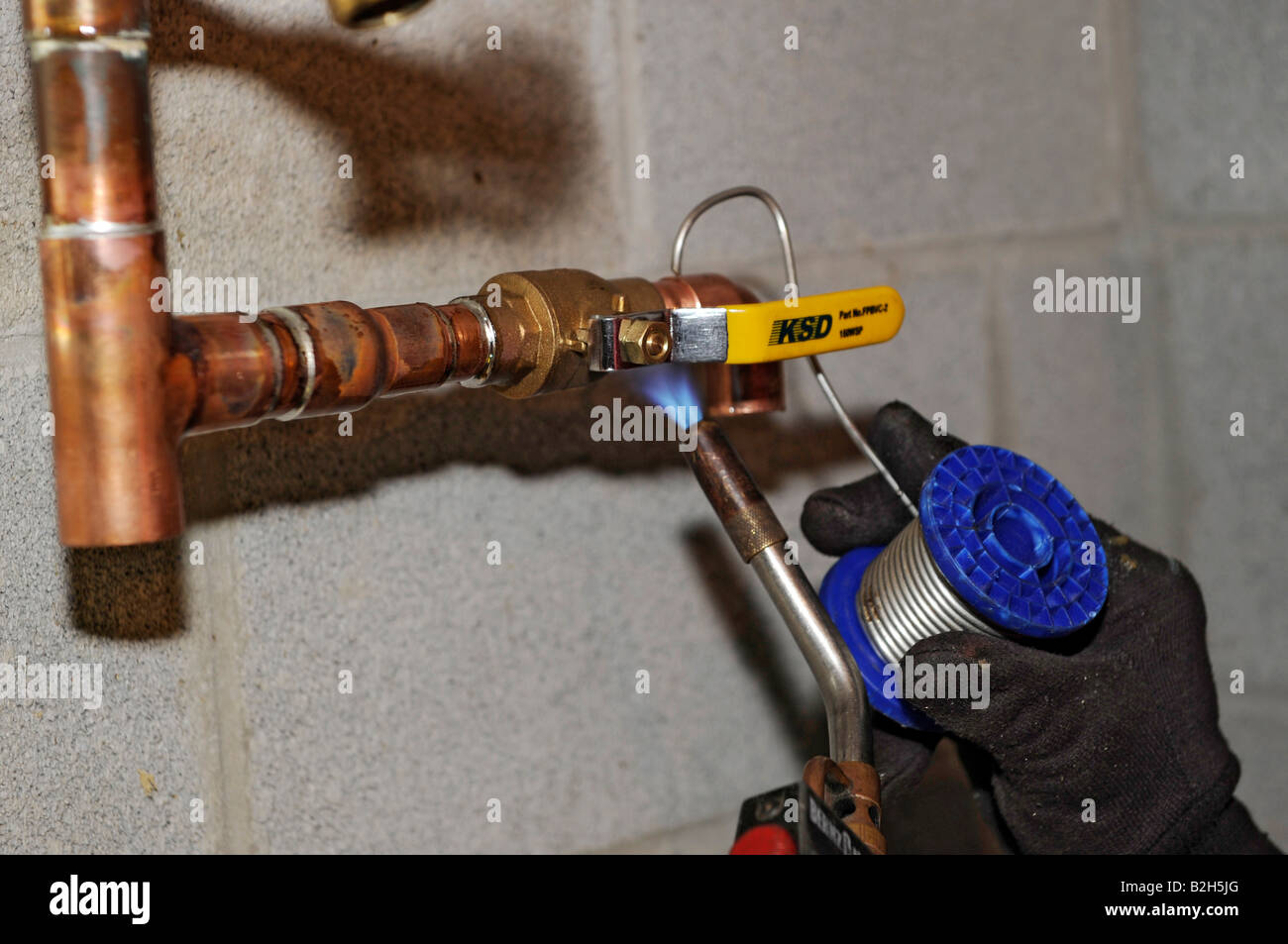 Plumber installing copper water piping for new residential home Stock Photo
