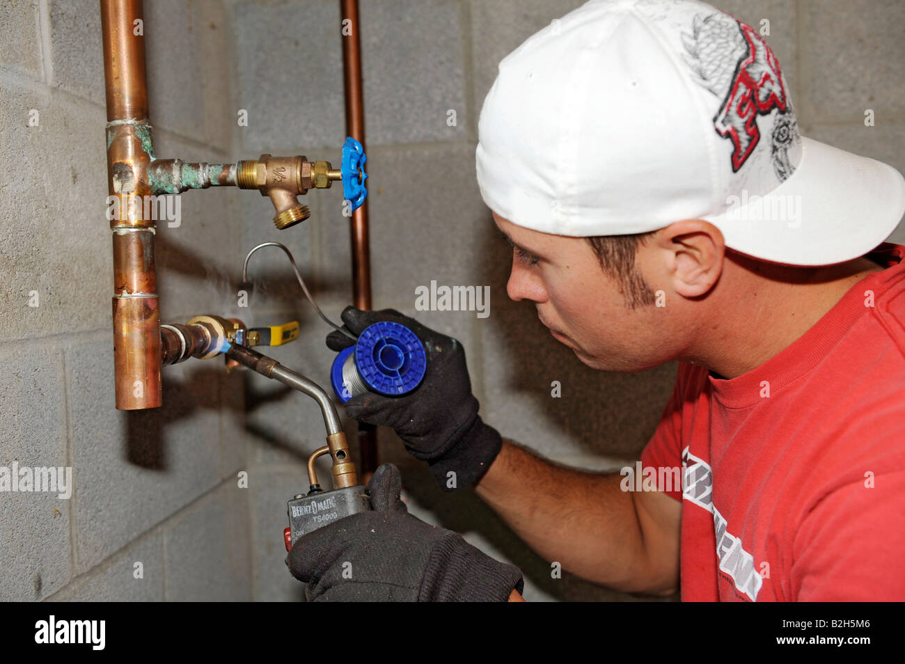 Plumber installing copper water piping for new residential home Stock Photo