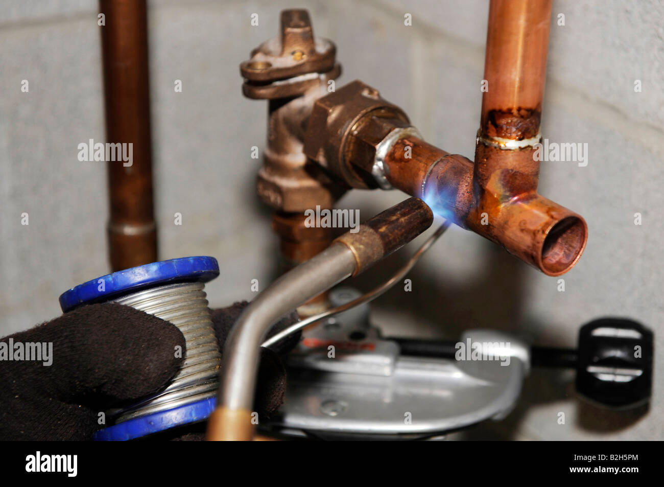 Plumber installing copper water piping for new residential home Stock Photo