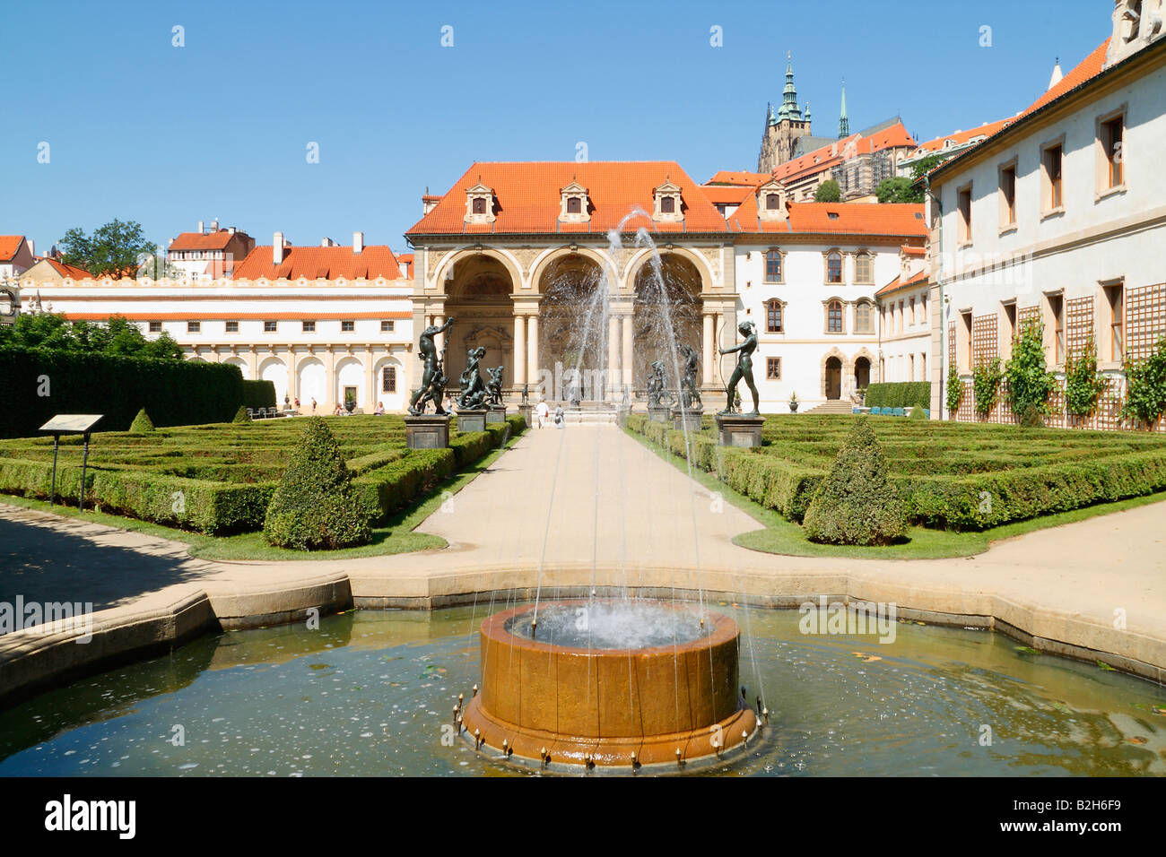 The view of the Prague s Palace Gardens with the small fontain and the alley with bronze statues of the mythological gods Stock Photo
