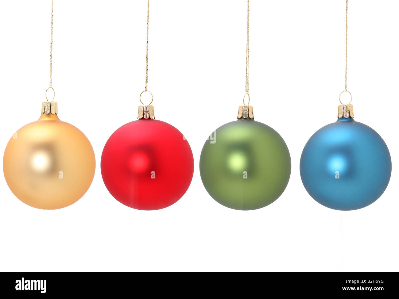 Four christmas balls hanging from golden thread Gold Red Green and Blue shot in studio isolated on white postprocessing minimal Stock Photo