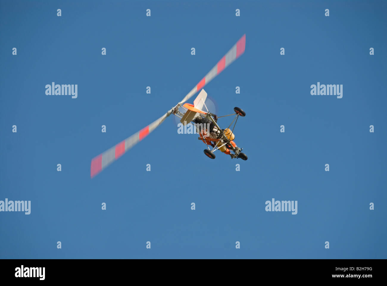 Stock photo of a single autogyro flying against a blue sky The photo was taken during a aviation dislplay in Estivol France Stock Photo