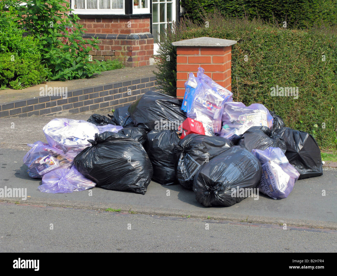 Rubbish refuse awaiting collection on the street outside a house Stock