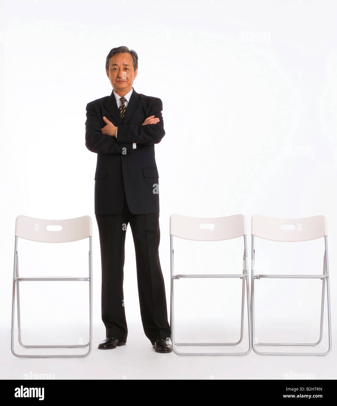 Portrait of a businessman standing with his arms crossed and smiling ...