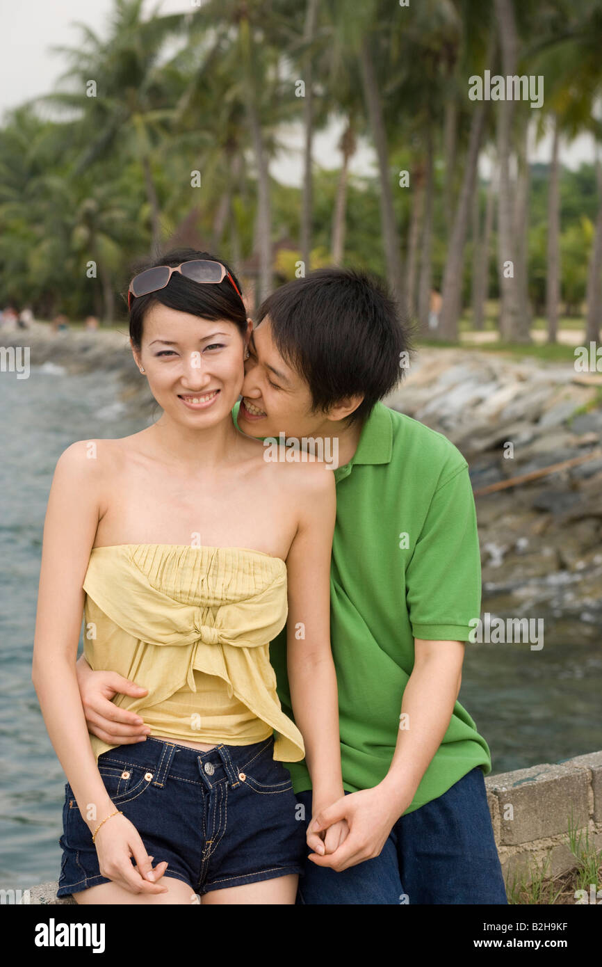 Mid adult man embracing a mid adult woman on the beach and smiling ...