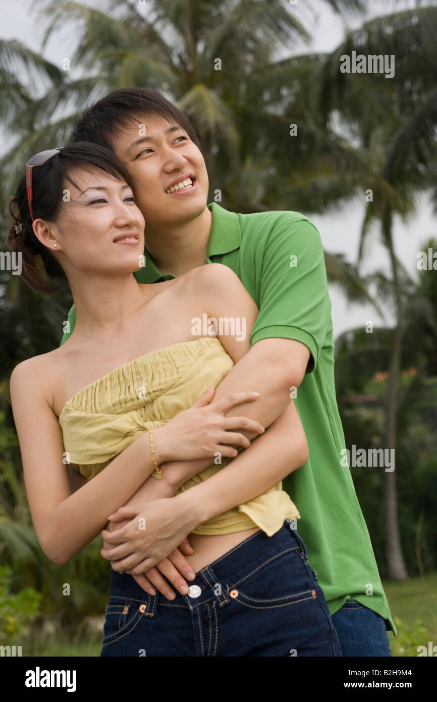 Mid adult man embracing a mid adult woman on the beach and smiling ...