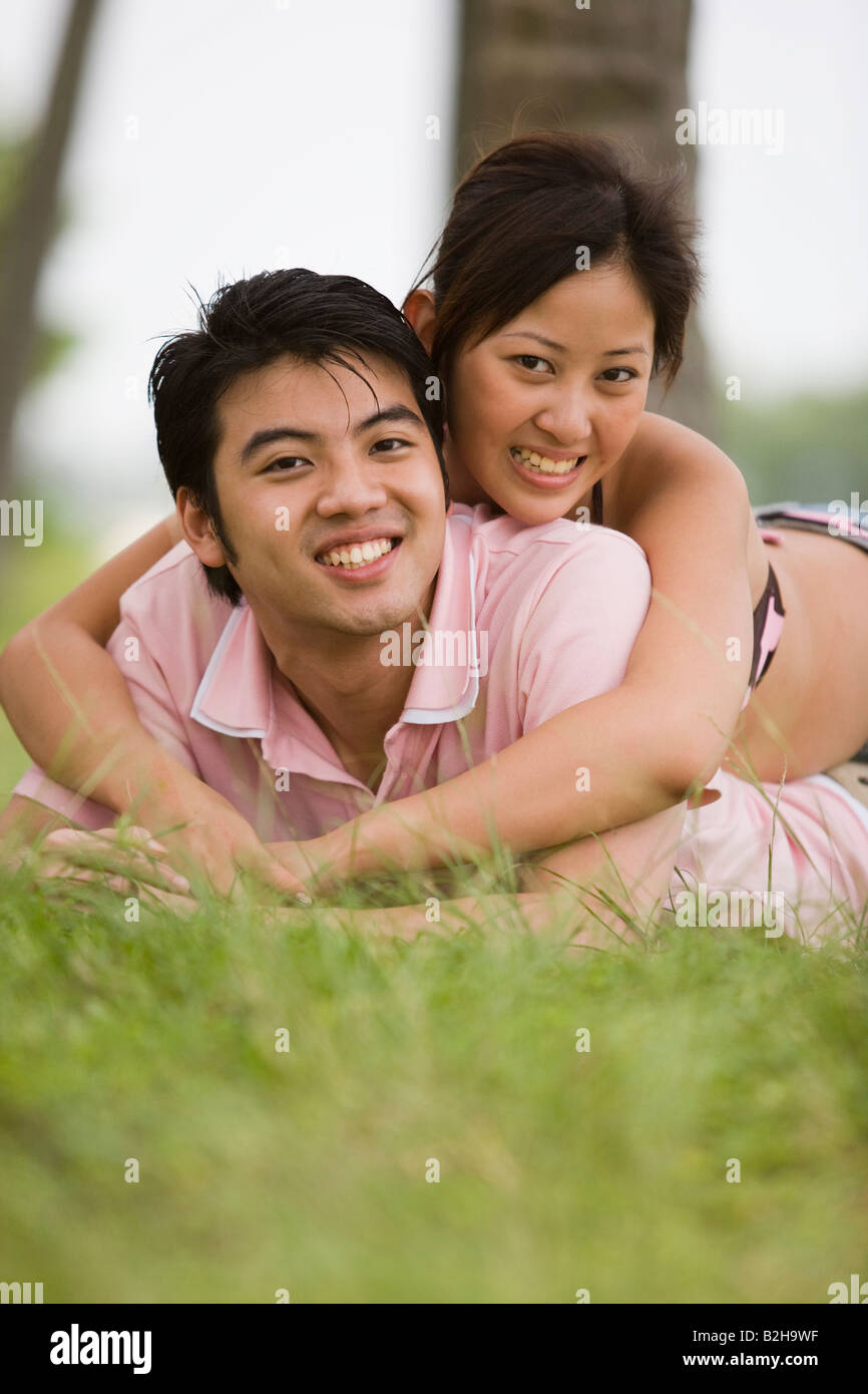 Portrait of a young woman lying on a young man and smiling Stock Photo ...