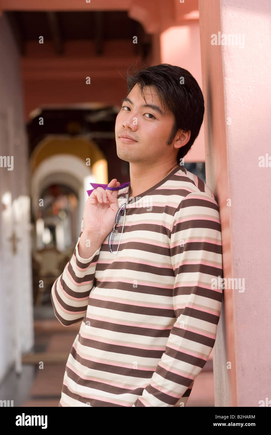 Portrait of a young man standing and holding shopping bags Stock Photo ...