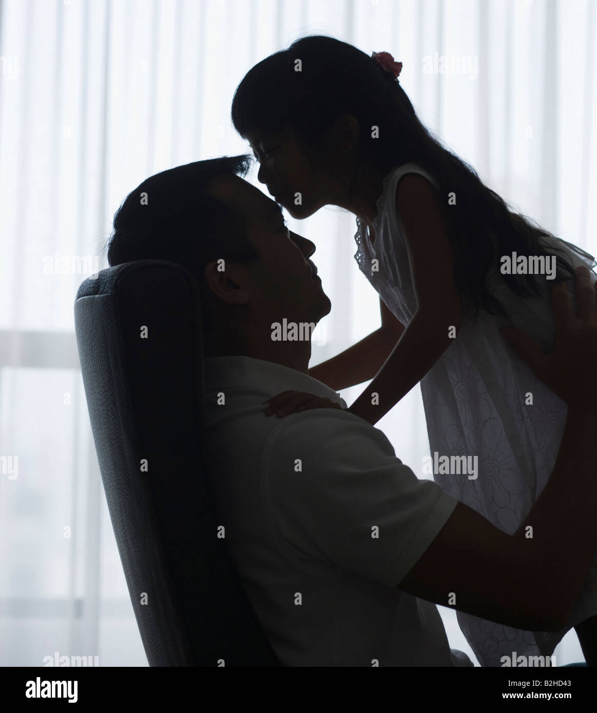 Side profile of a girl kissing on forehead of her father Stock Photo