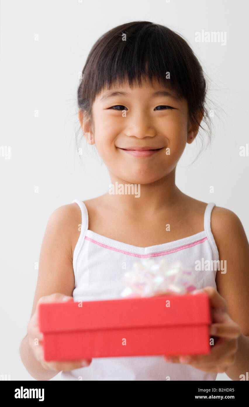 Portrait of a girl holding a gift box and smiling Stock Photo - Alamy